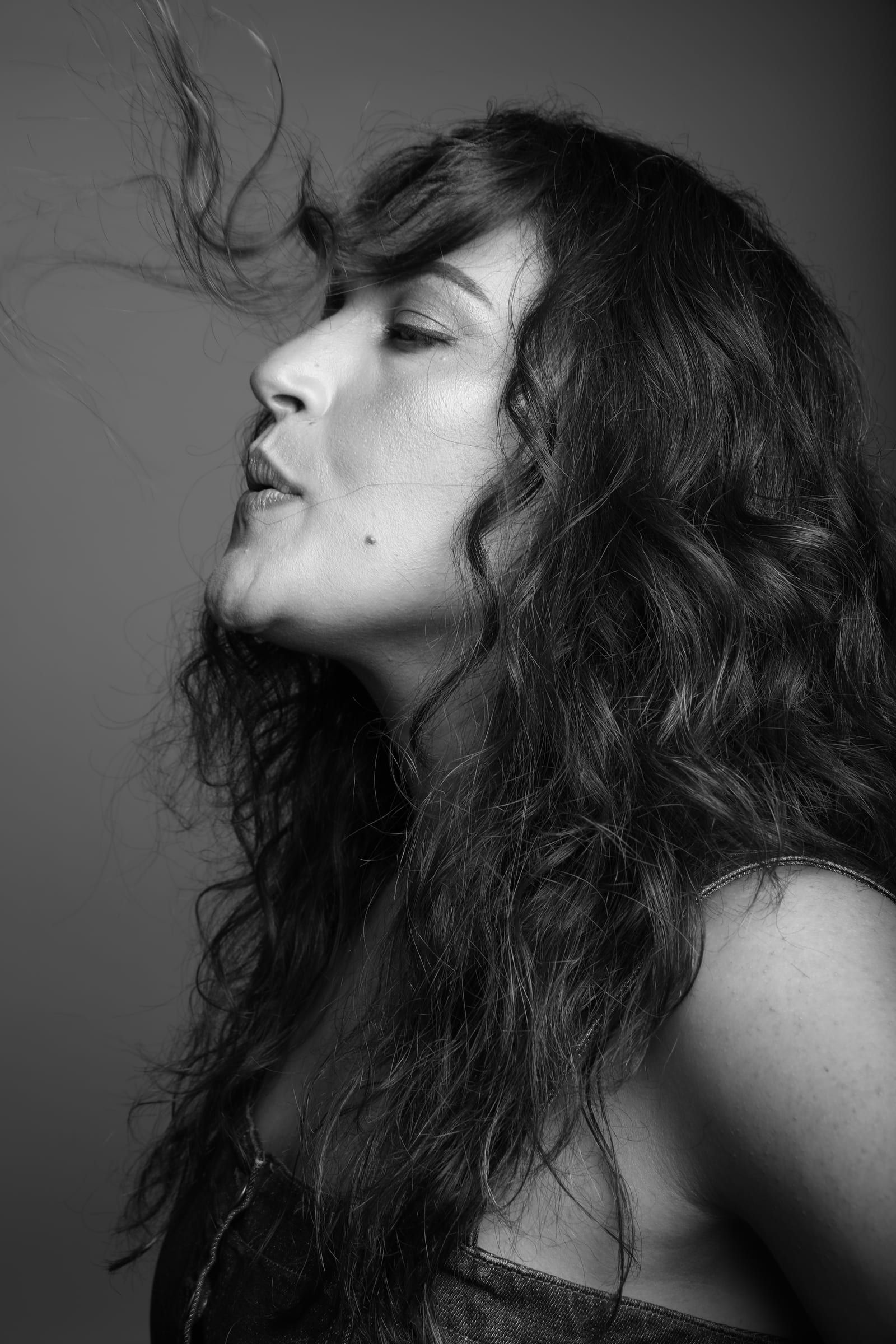 Noam Shuster-Eliassi in profile, eyes closed, hair in motion